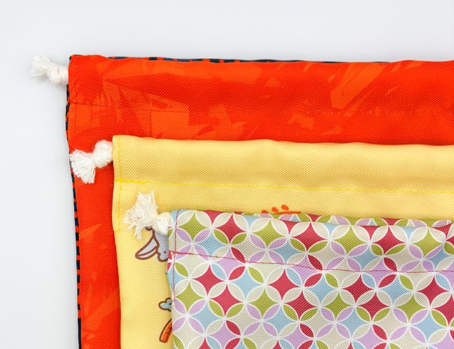 オリジナル巾着の縫製部分のアップ 3種類の巾着にあった糸色が使われている